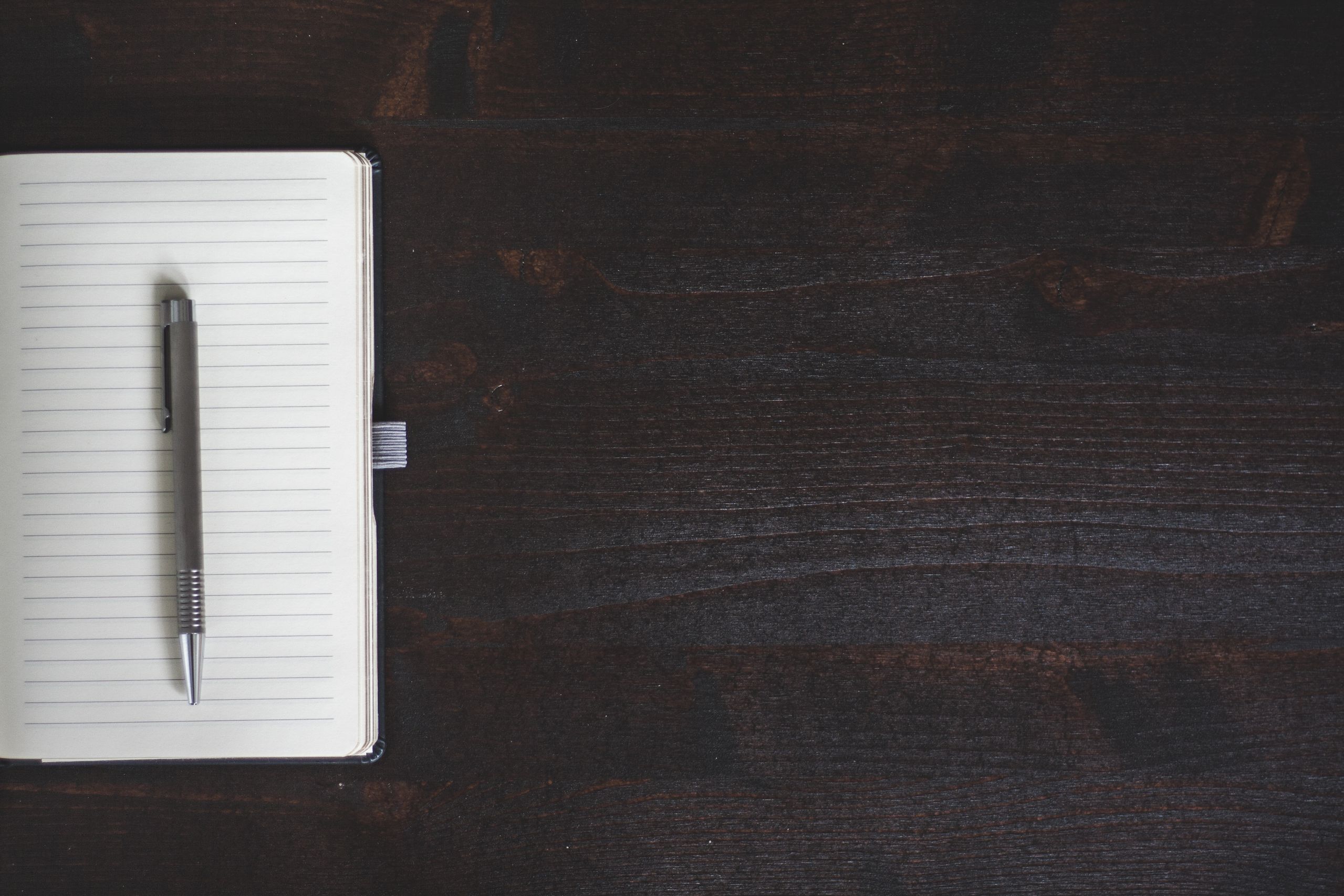 Open journal with handwriting and green notebook
